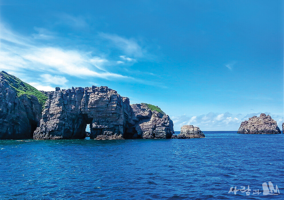 검푸른 홍도 앞 바다에 몸을 담근 독립문바위.